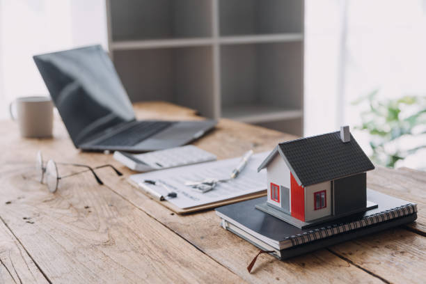 istock Real estate broker agent presenting and consult to customer to decision making sign insurance form agreement, buy and sell home model, concerning mortgage loan offer for and house insurance 1976830362