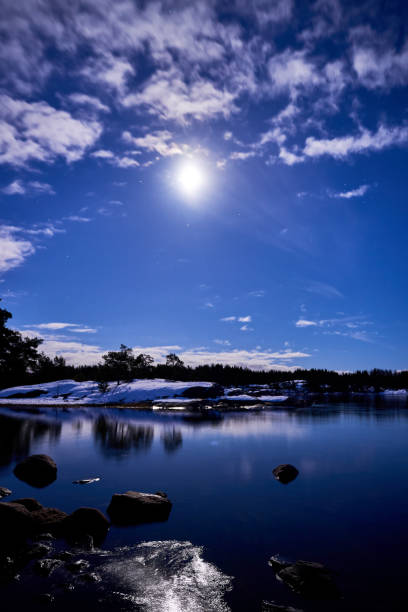 istock Snowy mountains and trees under a sunny blue sky 1976836347