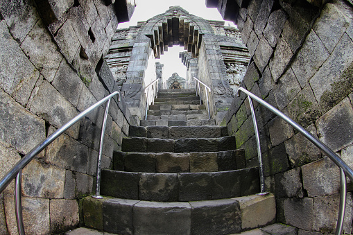 nterior of ancient Borobudur Temple. Empty stairs through arches to access Borobudur terraces. Popular tourist and Buddhist pilgrimage destination.