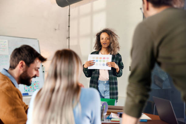 istock Black creative woman talking about plans with her colleagues in the office. 1976846106