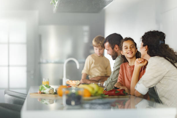 Family cooperating while making a meal in the kitchen.