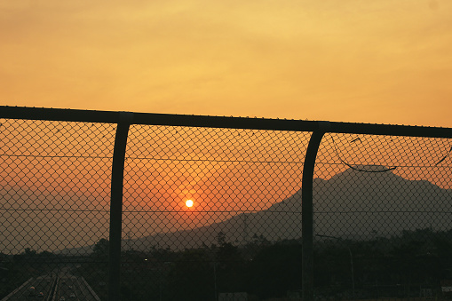 wire fence and mountains sunset background