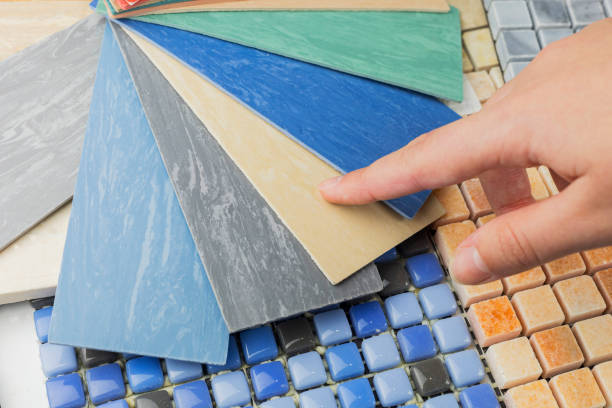 istock designer's hand choosing samples of interior stone material consists concrete tiles, quartz stones, artificial stones, graphic tile. 1976895725