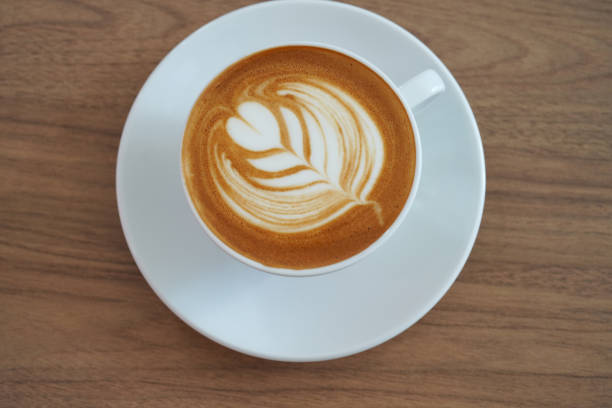 istock Hot latte coffee with latte art in the white cup on the white background. Copy space. 1976932524