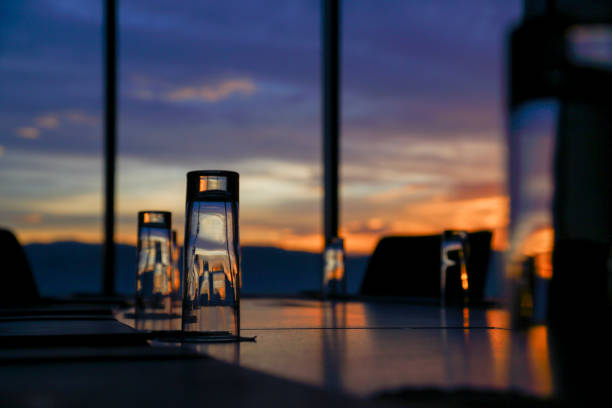 Evening view with sunset through window in an office with glasses on table. Workplace brokerage company business, board room waiting for the next busy day.