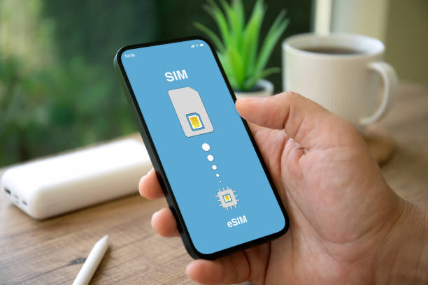 istock man hand hold phone with Sim card replacement on eSim 1977024951