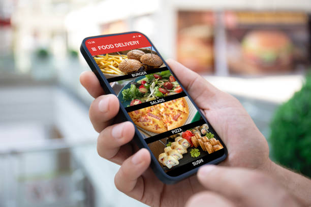 Man hand holding phone with food delivery app on screen