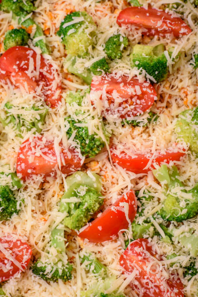 Delicious quiche with tomato, cheese, chicken, spices and herbs on a dark concrete background
