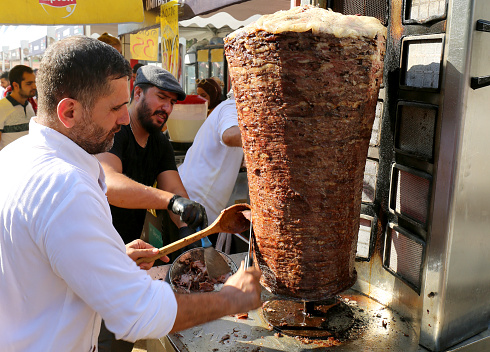 Adana, Turkey-October 09,2022:Unidentified Guy cutting Beef Doner Kebab for customers at Local Food Festival