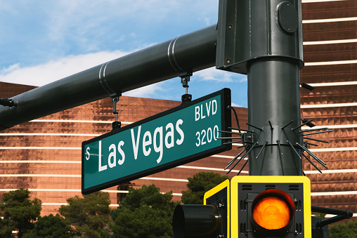 Close shot of a green Las Vegas blvd sign with a red traffic light up close