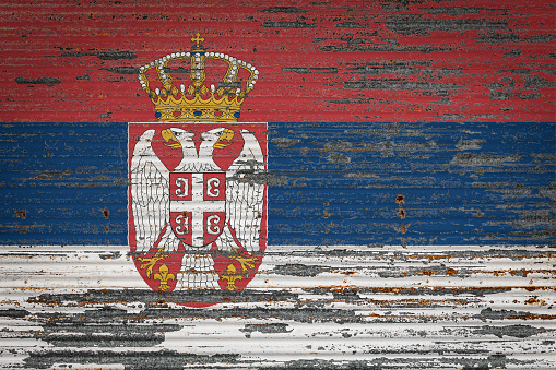 Close-up of old metal wall with national flag of Serbia. Concept of Serbia  export-import, storage of goods and national delivery of goods. Flag in grunge style