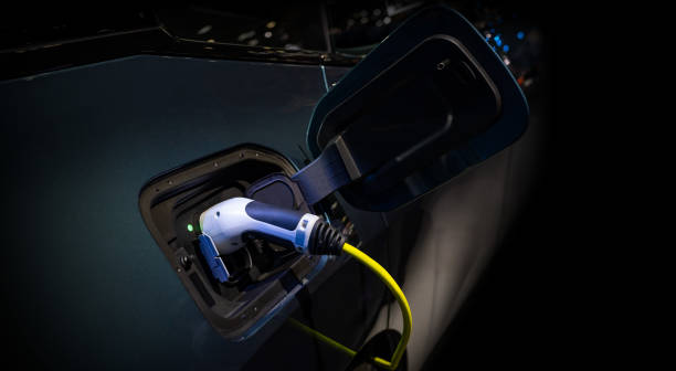 istock Power cable pump plug in charging power to electric vehicle EV car. 1977059872