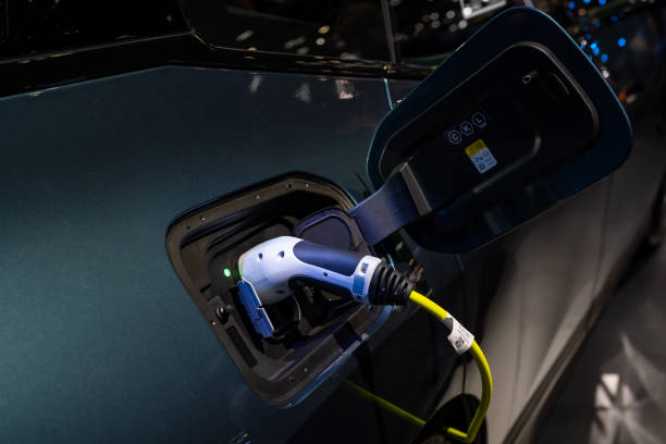 istock Power cable pump plug in charging power to electric vehicle EV car. 1977059874