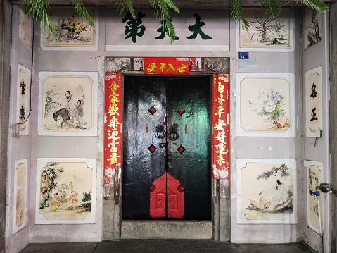 Ancient building door along Paifang street in Chaozhou City, a main street with paifang, also known as pailou, a traditional style of Chinese architecture, often used in arch or gateway structures. Chaozhou is a cultural center of the Chaoshan region in Guangdong province.
