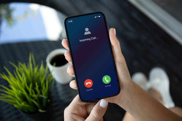 istock female hands hold phone with incoming call screen in cafe 1977063809