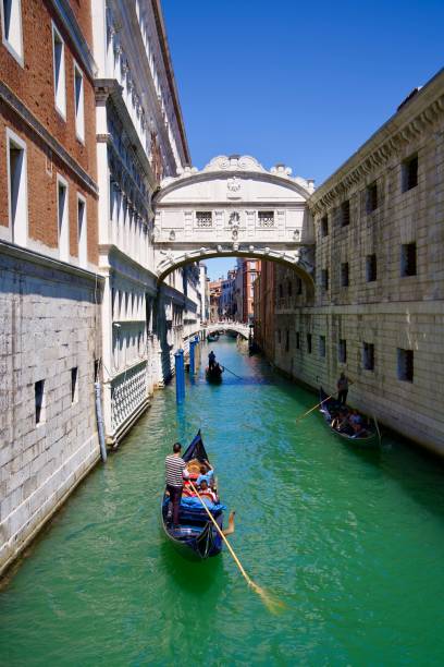 scenic diminishing view of canal with gondolas and stone bridge at italian city of venice. - european culture architecture vertical venice italy ストックフォトと画像