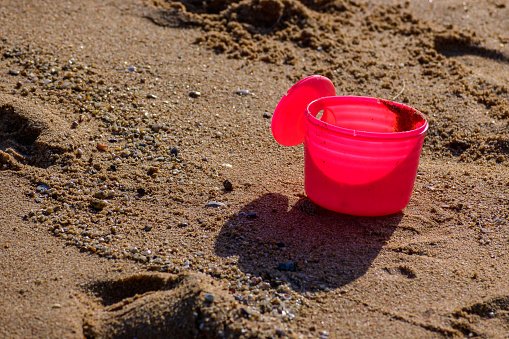 Plastic can scoops up pink sand at Pattaya beach.