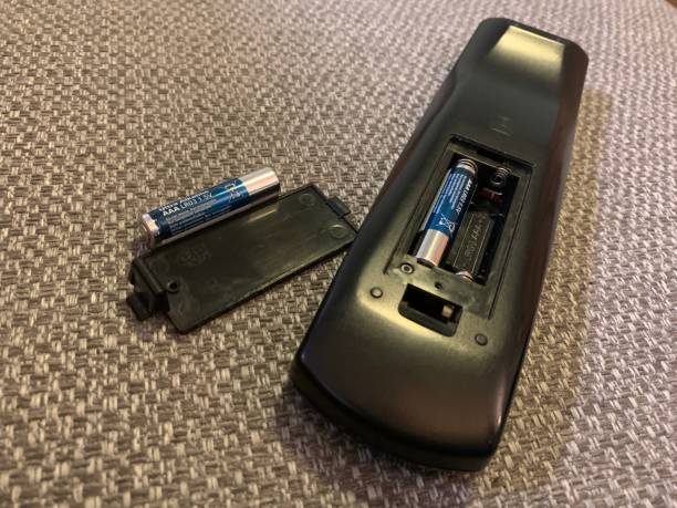 istock Black TV remote laying face down on sofa with battery cover removed 1977100838