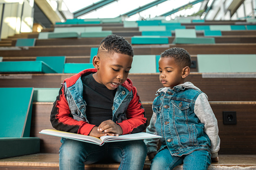 A group of young black and diverse school children in a dutch library