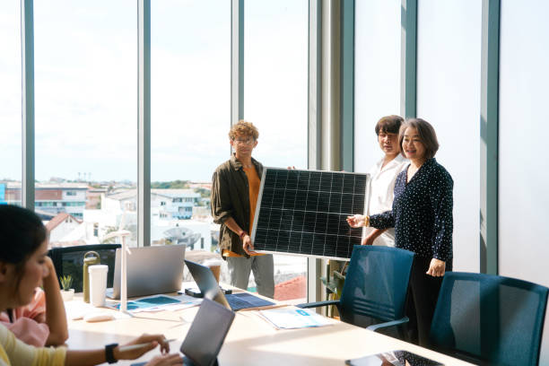 istock Colleagues examine a solar panel in a bright conference room, symbolizing teamwork in sustainable energy. 1977127897