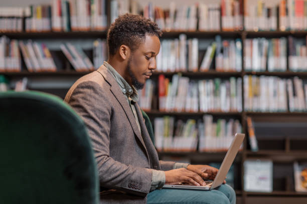 istock Portrait of a young adult black reader in a library 1977149630