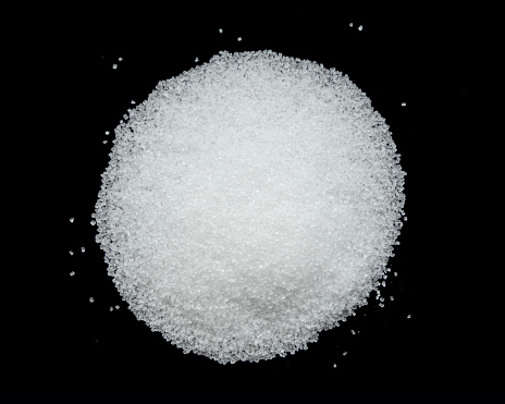 Small pile of sugar, top view, on black background