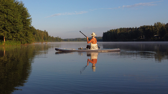 Three men fishing on a lake during a cloudy sunset of summer in Quebec.