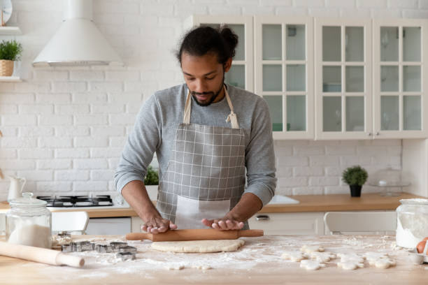 istock Focused young African American man baking cookies in home kitchen 1977176973