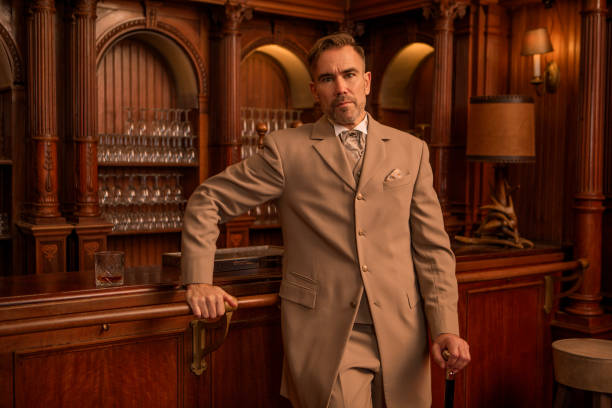 A handsome elegant 1920s style gentleman in a luxury stately home