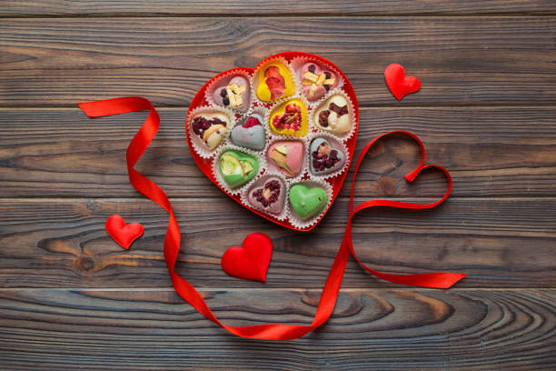 Valentine day composition: sweet candy, with gift boxes with bow and red felt hearts, photo template, background. Top View with copy space.