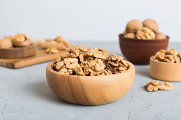 istock Fresh healthy walnuts in bowl on colored table background. Top view Healthy eating bertholletia concept. Super foods 1977193686