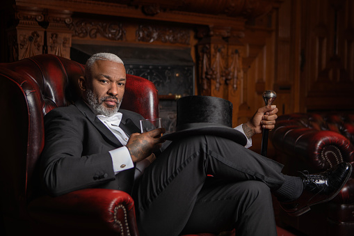 A handsome elegant 1920s style black gentleman in a luxury stately home