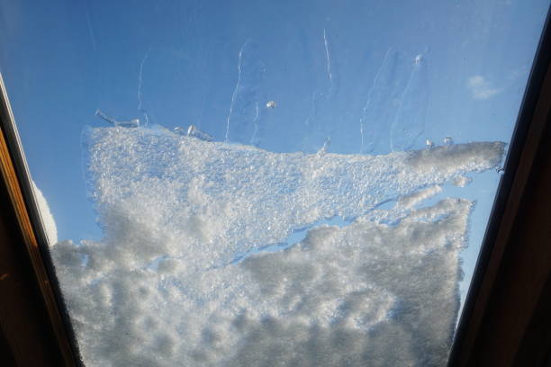 istock Snow on a roof window on a sunny day. 1977195898