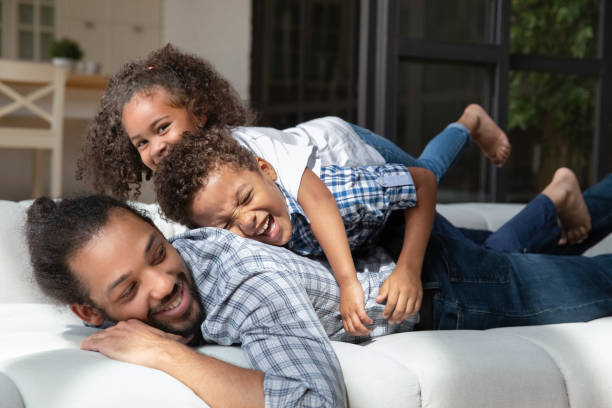 istock Joyful excited stacked sibling kids lying on dads back 1977195907