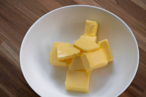 istock Butter slices are placed on a plate, Cut butter into cubes for baking cake 1977195928