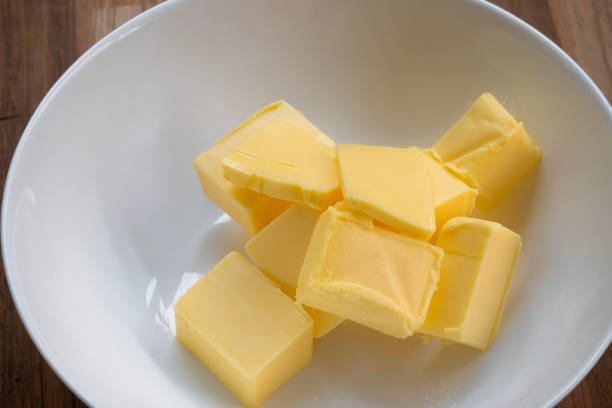 istock Butter slices are placed on a plate, Cut butter into cubes for baking cake 1977196445
