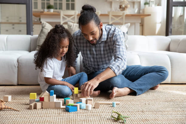istock Happy African dad and daughter girl completing construction model 1977198034