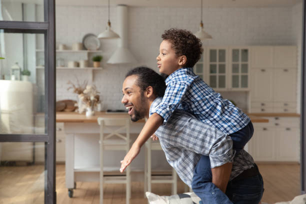 istock Happy African father and son enjoying active games at home 1977201239
