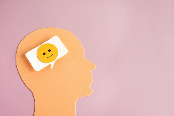 istock Head with happy thoughts. A symbol of a human head and a bubble with a positive face inside. 1977211903