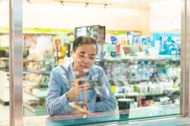 istock Asian man watching a video from his smart phone 1977259998