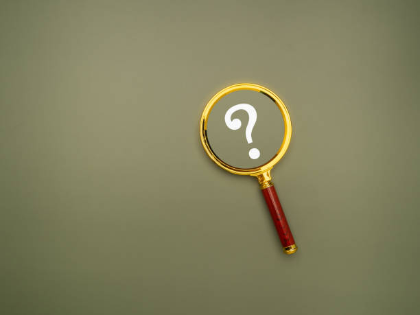 istock A magnifying glass with a white question mark on a green background. 1977271495