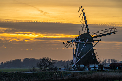 Historical dutch windmill in the town of Abcoude by sunset