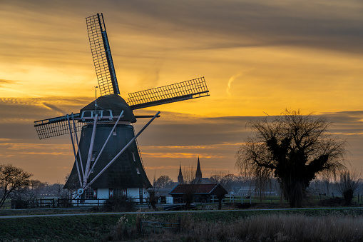Idyllic dutch landscape with traditional windmill in Abcoude at dusk