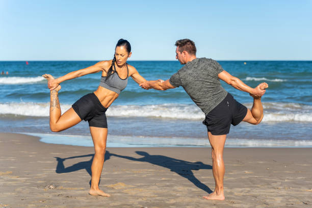 istock Middle aged couple exercising together on the beach this summer 1977319090