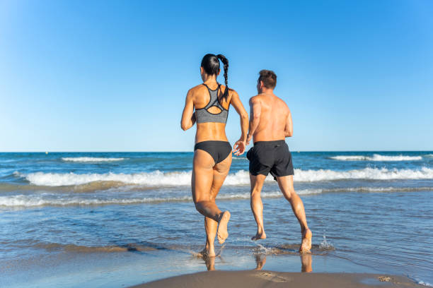 istock Middle aged couple exercising together on the beach this summer 1977320087
