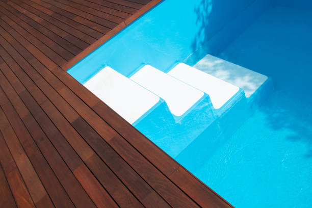 istock Swimming pool stairs and ipe decking edge, inground pool steps access into pool 1977328327