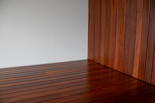 Hardwood flooring, indoor ipe wood floor and cladding with white wall corner empty space