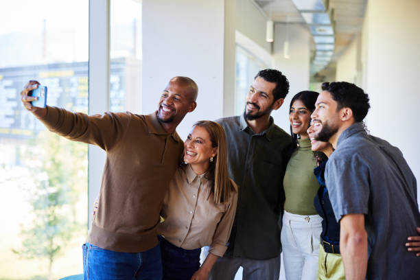 istock Diverse businesspeople smiling while taking a selfie in an office corridor 1977340651