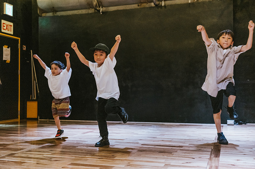 Japanese kids immersed in a hip hop breakdance class, each child contributing their unique style to the dynamic dance floor.