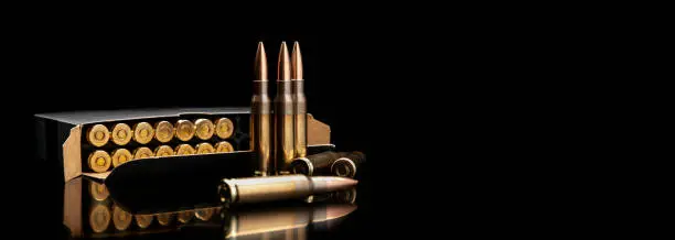 Bullet isolated on black background with reflexion. Rifle bullets close-up on black back. Cartridges for rifle and carbine on a black.